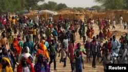 Des personnes déplacées courent à l'arrivée du ministre de l'Intérieur du Niger, Mohamed Bazoum, dans un camp de la ville de Diffa suite aux attaques des combattants de Boko Haram dans la région de Diffa au Niger, le 18 juin 2016.