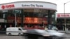 FILE - Vehicles speed past a Toyota dealership in Sydney.