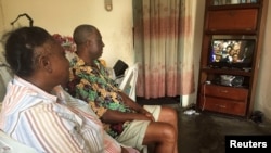 Un couple regarde à la télé la cérémonie d'investiture du président Ali Bongo à Libreville, Gabon, le 27 septembre 2016.