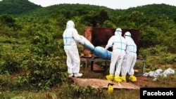 FILE - Health workers prepare to cremate the body of a COVID-19 patient in Kampong Trach District of Cambodia's southwestern Kampot province in June 2021. (Facebook/Kampot Provincial Police Department)
