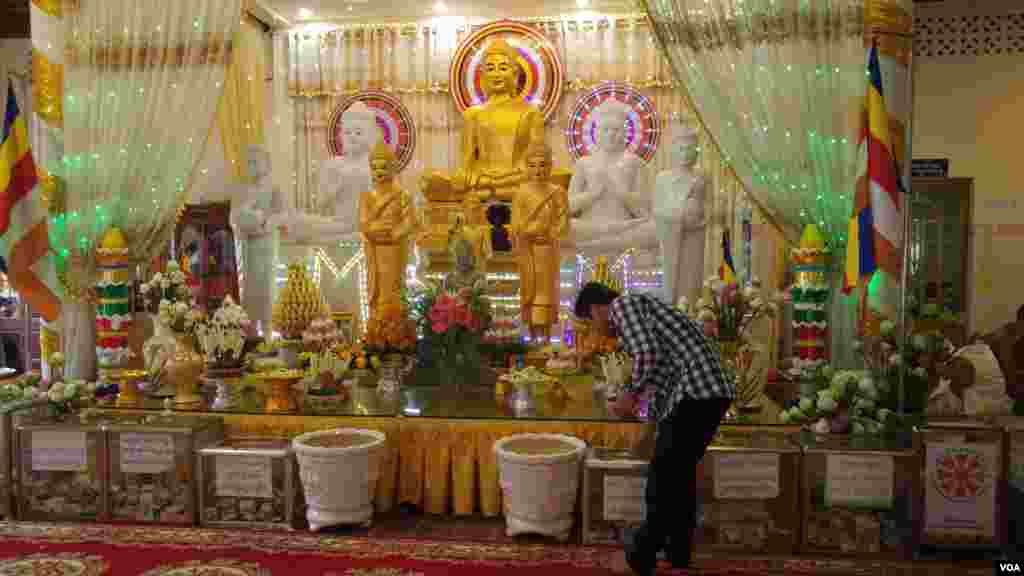 បុរសម្នាក់ដាក់បច្ច័យនៅក្នុងហិបបច្ច័យនានា នៅក្នុងវត្តសំពៅមាស ក្នុងរាជធានីភ្នំពេញ នៅថ្ងៃកាន់បិណ្ឌទី៥ (ថ្ងៃទី២១ ខែកញ្ញា ឆ្នាំ២០១៦)។ (ប៊ុន ប៉េងហ៊ុយ/VOA)