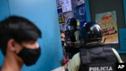 Miembros de la Policía Nacional ordenan al propietario de un negocio cerrar su tienda para frenar la propagación del COVID-19 en Caracas, el 21 de mayo de 2021.
