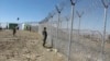 Pakistani soldiers stand guard at a newly erected fence between Pakistan and Afghanistan at Angore Adda, Pakistan, Oct. 18, 2017. 