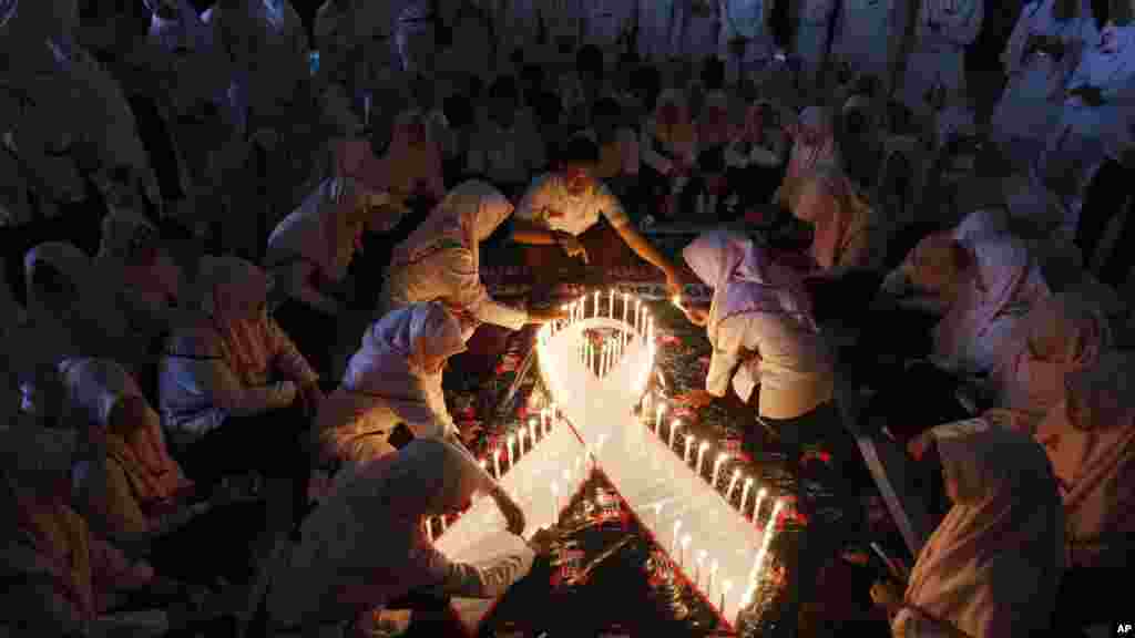 Des bougies allumées par des étudiants indonésiens en médecine lors d'une veillée à l’occasion organisée de la journée mondiale de lutte contre le sida à Surabaya, Java-Est, Indonésie, 1er décembre 2015. 
