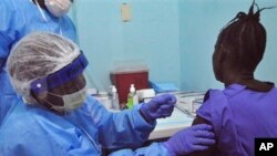Une femme reçoit un vaccin dans le cadre d'un essai de vaccin contre le virus Ebola dans le plus grand hôpital de Monrovia, au Liberia, le 2 février 2015.