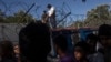Hungarian police and army officers oversee the distribution of food as people queue at a camp in Horgos, Serbia, on Serbia's border with Hungary, July 11, 2016. 