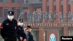 在世衛組織新冠病毒源頭調查組視察武漢的中國科學院病毒研究所期間，中國保安人員在研究所外站崗。 （路透社 2021年2月3日）