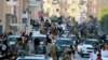FILE - Fighters from the Islamic State group parade in Raqqa, north Syria, earlier this year. 