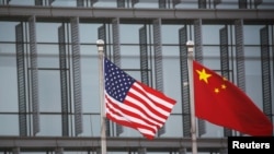 美中國旗在一家美國公司駐北京的辦公樓外飄揚。（2021年1月21日）