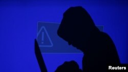 FILE - Three suspects have been accused of attacking more than 100 U.S. companies in recent years and stealing millions of customer credit and debit card records.