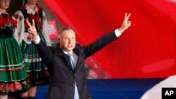 Le président Andrzej Duda faisant des signes de victoire après la fin du vote à l'élection présidentielle à Lowicz, Pologne, dimanche 28 juin 2020. (AP Photo / Petr David Josek)