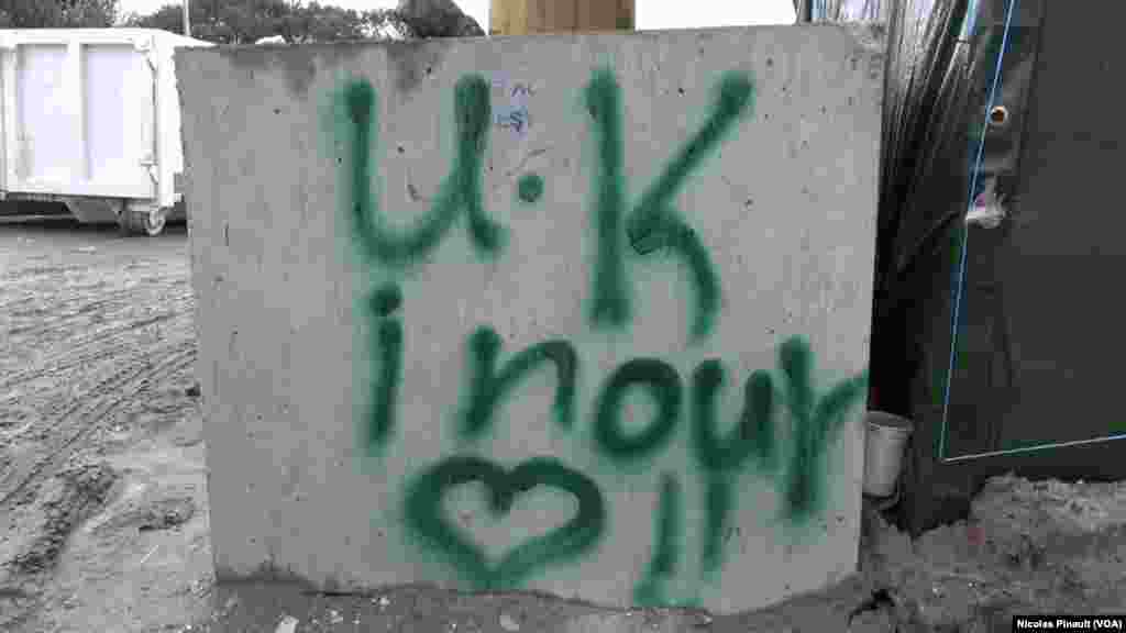 Un grafiti dans la "jungle". Ce camp est situé aux abords de Calais dans le nord de la France, 14 octobre 2015 (Nicolas Pinault/VOA).