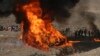 FILE - Afghan security personnel watch as flames and smoke rise after opium and narcotics are burned in a ceremony in Kabul, Afghanistan, Dec. 20, 2016. 