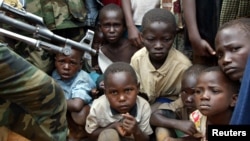 Un soldat armé du groupe rebelle UPC de la RDC monte la garde lors d'un rassemblement organisé par le chef rebelle Thomas Lubanga dans un village où se sont réfugiés les victimes des conflits Lundu-Hema, le 5 juin 2003. REUTERS / Antony Njuguna AN / 