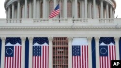 Американские флаги вывешены на западном фасаде Капитолия перед предстоящей инаугурацией избранного президента Дональда Трампа