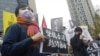 FILE - A supporter holds a sign reading 'Support Press Freedom in Hong Kong' to protest outside of the Bank of China in Taipei, Dec. 30, 2021.