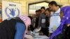 Syrian refugees lined up at a distribution center to receive a new debit bank card through which all aid agencies transfer their aid, at Bar Elias town in Lebanon's Bekaa valley, Oct. 25, 2016. 