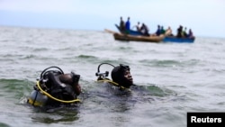 Des membres de la police ougandaise participent à des opérations de sauvetage après le chavirement d'un bateau transportant principalement des réfugiés congolais sur le lac Albert, au sud-ouest de la capitale ougandaise, Kampala, le 23 mars 2014.