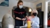Una paciente recibe una dosis de la vacuna Pfizer-BioNTech Covid-19 por un bombero, en su casa en Les Matelles, sur de Francia, el 19 de marzo de 2021.