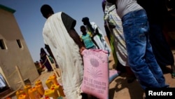 Un homme repart avec un sac de riz dans un centre de distribution alimentaire géré par l'ONG espagnole Accion contra el Hambre (Action contre la Faim) en Tarenguel, région du Gorgol, en Mauritanie, 30 mai 2012. REUTERS / Susana Vera (MAURITANIE - Tags: SOCIETYENVIRONNEMENT DE CATASTROPHE) - RTR32UQ2