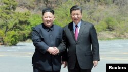 中國國家主席習近平 (右) 在大連與到訪的北韓領導人金正恩握手。 （2018年5月9日）