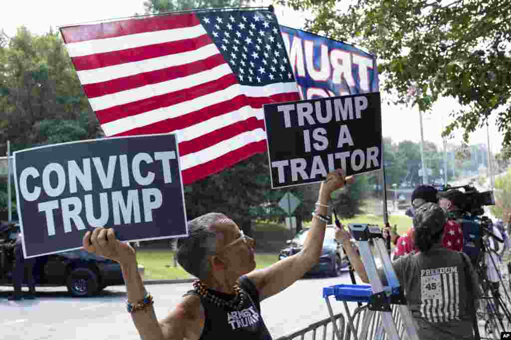 អ្នកប្រឆាំងនឹងលោក Donald Trump ម្នាក់ដែលបានធ្វើដំណើរពីក្រុង New York លើកបដានៅខាងក្រៅពន្ធនាគារស្រុក Fulton ក្រុង Atlanta រដ្ឋ Georgia កាលពីថ្ងៃទី២៤ ខែសីហា ឆ្នាំ ២០២៣។