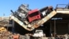 Damaged vehicles pile on a damaged roof of a car mechanic service center in Ramousah area southwest of Aleppo, Syria August 2, 2016. 