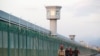 FILE PHOTO: Workers walk by the perimeter fence of what is officially known as a vocational skills education center in Dabancheng in Xinjiang Uighur Autonomous Region, China,Sept. 4, 2018. 