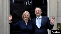 英國新首相卓慧思(Liz Truss)同她丈夫休·奧利瑞2022年9月6號在唐寧街10號門口向人們招手致意。