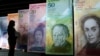 Una mujer mira versiones de gran tamaño de la entonces nueva moneda venezolana, el bolívar, en Caracas, el 24 de octubre de 2007. 