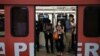 Passengers using their phones, wear masks to protect themselves from coronavirus in a Light Rail Transit train in Kuala Lumpur, Malaysia, Feb. 10, 2020.