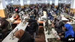 Des dizaines de femmes veuves de la guerre en Afghanistan cousent des uniformes militaires ans une usine de Kaboul, le 8 février 2021. (Photo AFP/ WAKIL KOHSAR)