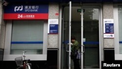 一名婦女正在離開上海浦東發展銀行開設在北京的一所支行。（路透社） 