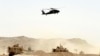 FILE - A US military helicopter flies over the site of a suicide bomb that struck a NATO convoy in Kandahar south of Kabul, Afghanistan, Aug. 2, 2017.