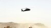 FILE - A US military helicopter flies over the site of a suicide bomb that struck a NATO convoy in Kandahar south of Kabul, Afghanistan, Aug. 2, 2017.