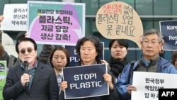 Mwanaharakati akiwa pamoja na waandamanaji wanaotaka "plastiki izuiliwe kutumika" katika viwanja vya BEXCO, ukumbi ambao Kamati ya UN ya Mazungumzo ya Kiserikali kuhusu Uchafuzi wa Plastiki (INC-5) yaliyofanyika huko Busan Novemba 25, 2024.