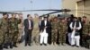 Afghanistan President Ashraf Ghani, center, poses with U.S. and local military officials during a ceremony after receiving two Black Hawk helicopters from the U.S. government, at Kandahar Air Field, Afghanistan, Oct. 7, 2017.