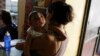 FILE - Ericka Torres holds her 3-month-old son, Jesus, who was born with microcephaly, at their home in Guarenas, Venezuela, Oct. 5, 2016. 