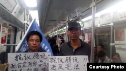 趙海通(右)2013年年初在廣州地鐵上舉牌 (民生觀察圖片)
