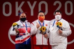 Gold medalist Li Wenwen of China, center, poses with silver medalist Emily Campbell of Britain, left, and bronze medalist Sarah Robles of the U.S., in the medals ceremony for the women's +87kg weightlifting at the 2020 Summer Olympics, Aug. 2, 2021.