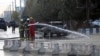 Afghan firefighters clean up the site of a deadly suicide bombing, in Kabul, Afghanistan, Nov. 16, 2017. 