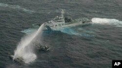 日本海岸警衛隊提供的照片顯示警衛隊使用水炮驅逐台灣船隻