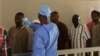 A health worker, center, takes the temperature of people to see if they might be infected by the Ebola virus inside the Ignace Deen government hospital in Conakry, Guinea, March 18, 2016.