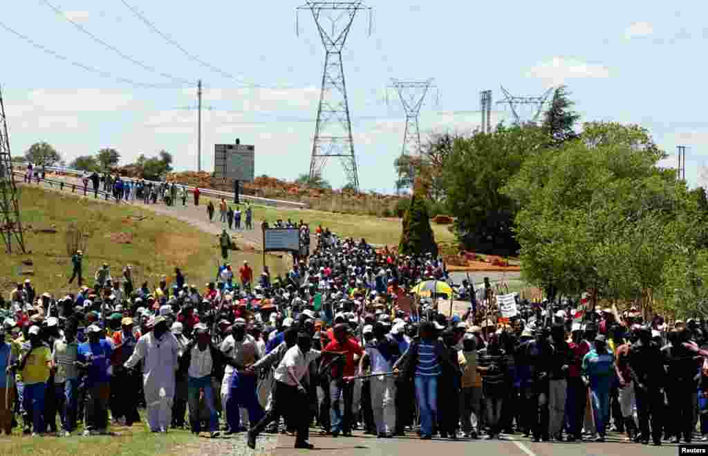 Striking miners march to meet some of the management team at the AngloGold Ashanti mine in Carletonville, South Africa, October 18, 2012.