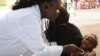 Une infirmière examine un enfant lors de tests de diagnostic de la pneumonie dans un centre de santé du quartier d'Attecoube à Abidjan, le 17 mars 2016.