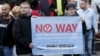 FILE - Supporters of the German far-right National Democratic Party (NPD) hold a placard during an anti-immigration march in Riesa, Germany, Sept. 9, 2015. 