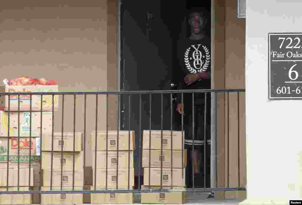 Un homme sort de la résidence de la famille mise en quarantaine pour récupérer les cartons de produits alimentaires que la Croix Rouge a déposés devant l’appartement où habitait le malade atteint d’Ebola, à Dallas, le 3 octobre 3014.