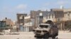 Un véhicule détruit par le feu, après une bataille dans une banlieue de Tripoli autrefois surpeuplée, en Libye, le 28 avril 2019.