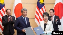 2023年12月16日，在日本東京首相官邸舉行的簽署儀式後，日本外相上川洋子（前右）與馬來西亞外長穆罕默德·哈桑（前左）合影。 （路透社）