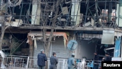 Les policiers afghans inspectent le lieu de l'attentat à Kaboul, en Afghanistan, le 28 janvier 2018. 